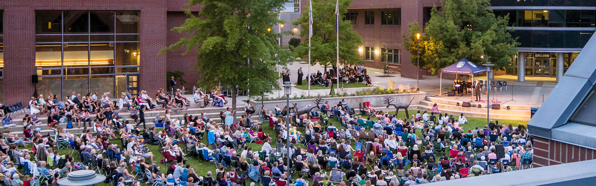 Attendees in the courtyard watching a performance at Opera Under the Stars.